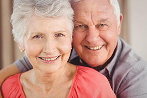 Senior couple in an embrace both with white hair smiling